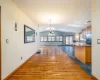 Unfurnished dining area with lofted ceiling, dark wood-type flooring, a baseboard heating unit, sink, and a notable chandelier