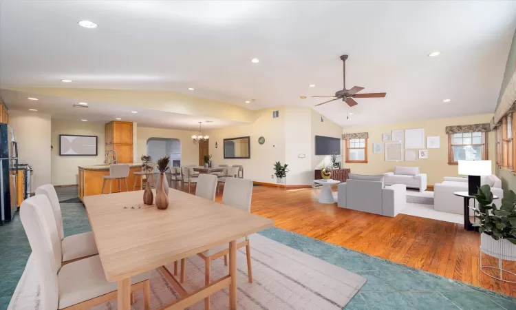 Dining area featuring hardwood / wood-style flooring, sink, lofted ceiling, and ceiling fan with notable chandelier