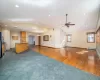 Unfurnished living room featuring ceiling fan, a baseboard radiator, dark hardwood / wood-style flooring, and vaulted ceiling