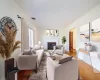 Living room featuring wood-type flooring, a brick fireplace, and crown molding