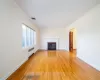 Unfurnished living room with a fireplace, radiator, ornamental molding, and light hardwood / wood-style flooring