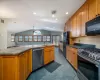 Kitchen with vaulted ceiling, ceiling fan, sink, dark stone countertops, and black appliances