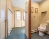 Bathroom featuring toilet and a baseboard heating unit