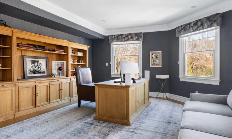 Home office with ornamental molding and light hardwood / wood-style flooring