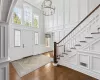 Foyer with plenty of natural light, hardwood / wood-style floors, beam ceiling, and an inviting chandelier