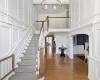 Entrance foyer with a high ceiling, dark wood-type flooring, crown molding, and a chandelier