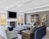 Living room featuring wood-type flooring, crown molding, and a fireplace