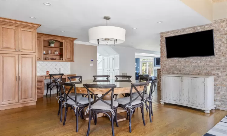 Dining room featuring dark wood-type flooring, ornamental molding, and built in desk