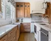 Kitchen with light stone countertops, appliances with stainless steel finishes, decorative backsplash, sink, and dark wood-type flooring