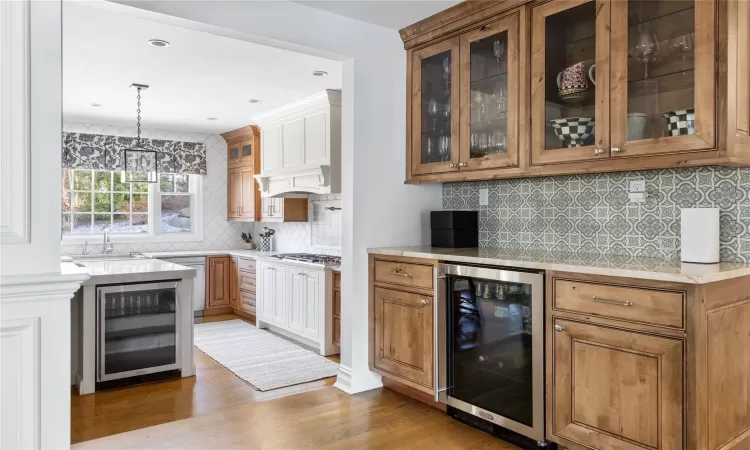 Kitchen featuring sink, pendant lighting, appliances with stainless steel finishes, and wine cooler