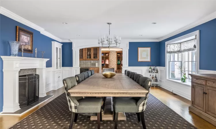 Dining room with an inviting chandelier, dark wood-type flooring, and crown molding