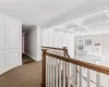 Hall with beam ceiling, a notable chandelier, hardwood / wood-style flooring, crown molding, and coffered ceiling