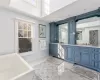 Bathroom with a towering ceiling, vanity, and a bath