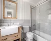 Full bathroom featuring crown molding, tile walls, and shower / bath combination with glass door