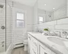 Full bathroom with tiled shower / bath, and double vanity