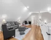 Living room with vaulted ceiling and light hardwood / wood-style flooring