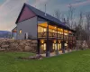 Back house at dusk with a lawn, a patio area, and a balcony