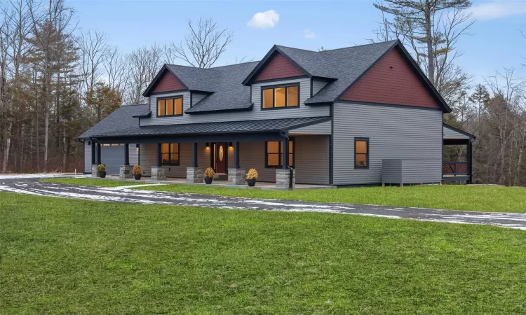 View of front facade featuring a front lawn and a porch