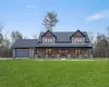 View of front of property featuring covered porch, a front lawn, and a garage