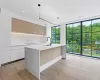 Similar kitchen with floor-to-ceiling windows.