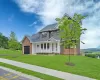 Craftsman inspired home featuring a front lawn and covered porch