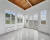 Open sunroom with beamed ceiling, radiator heating unit, and wooden ceiling