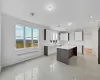 Kitchen with a kitchen island, white cabinetry, sink, and radiator