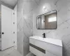 Bathroom with tile floors, tile walls, and vanity