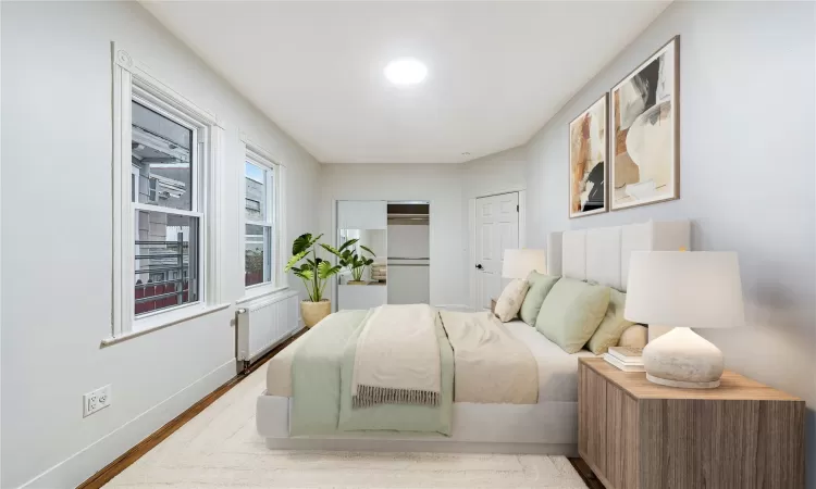 Virtually Staged Bedroom #1 with radiator heating unit and light hardwood / wood-style floors