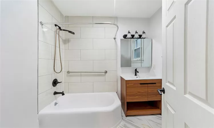 Bathroom with vanity and tiled shower / bath