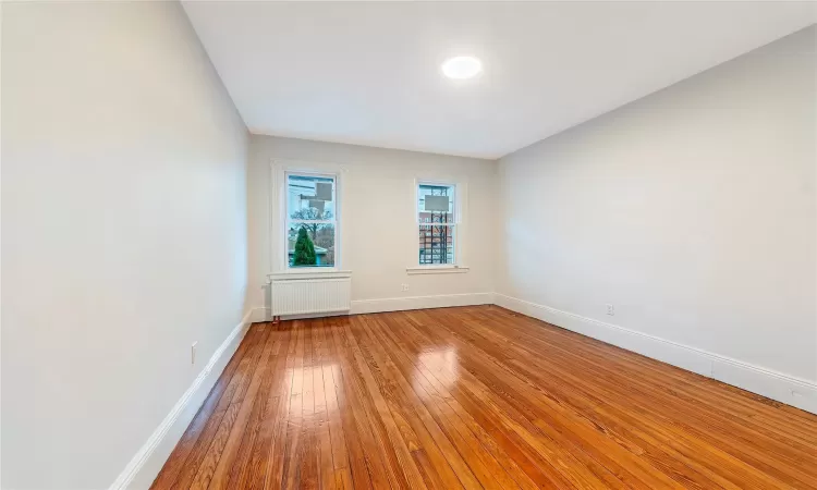 Unfurnished Bedroom #2 with radiator and hardwood / wood-style floors