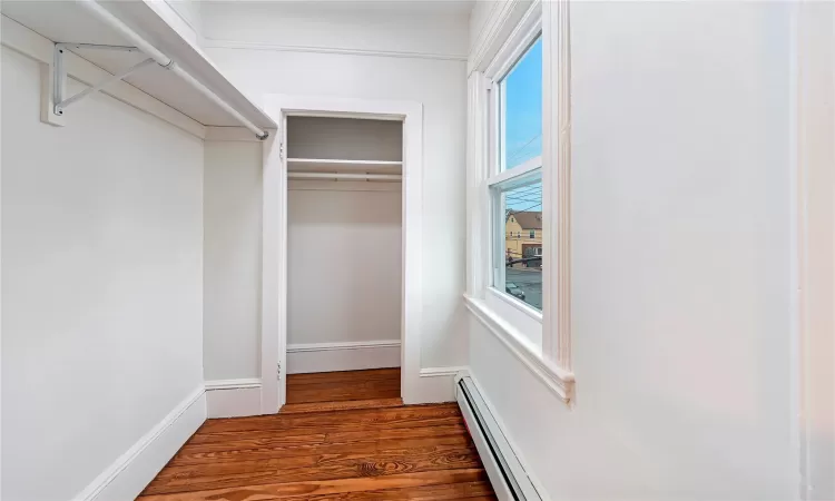 Walk in closet with dark wood-type flooring