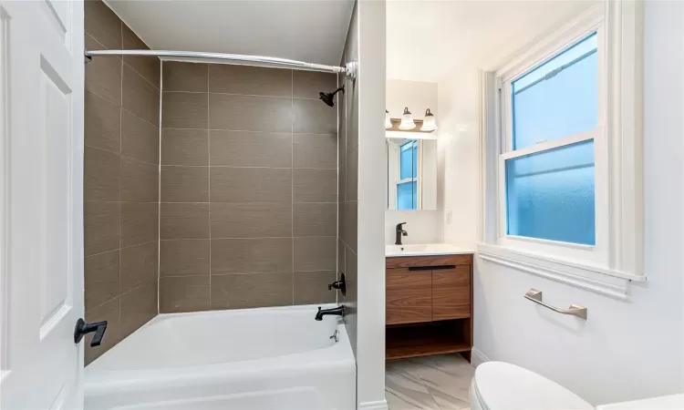 Full bathroom with vanity, toilet, and tiled shower / bath