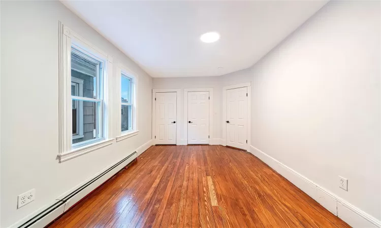 Bedroom. #2 with baseboard heating and dark hardwood / wood-style floors