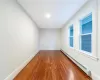 Second Angle of Bedroom #2 with dark hardwood / wood-style floors and a baseboard radiator