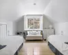 Bedroom with light hardwood / wood-style floors and vaulted ceiling