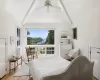 Bedroom featuring ceiling fan, light hardwood / wood-style floors, and vaulted ceiling with beams