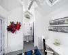 Bathroom featuring vaulted ceiling, wooden walls, and concrete flooring