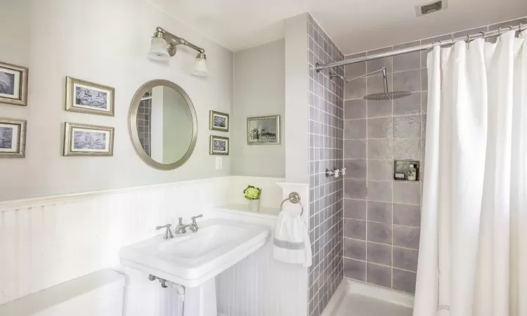 Bathroom featuring curtained shower and toilet