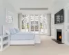 Bedroom with access to exterior, light colored carpet, and a tray ceiling