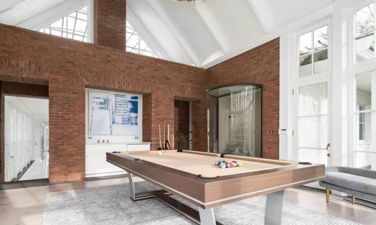 Playroom featuring brick wall, billiards, beam ceiling, and high vaulted ceiling