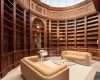 Wine area with built in shelves, light hardwood / wood-style flooring, wood walls, and a towering ceiling