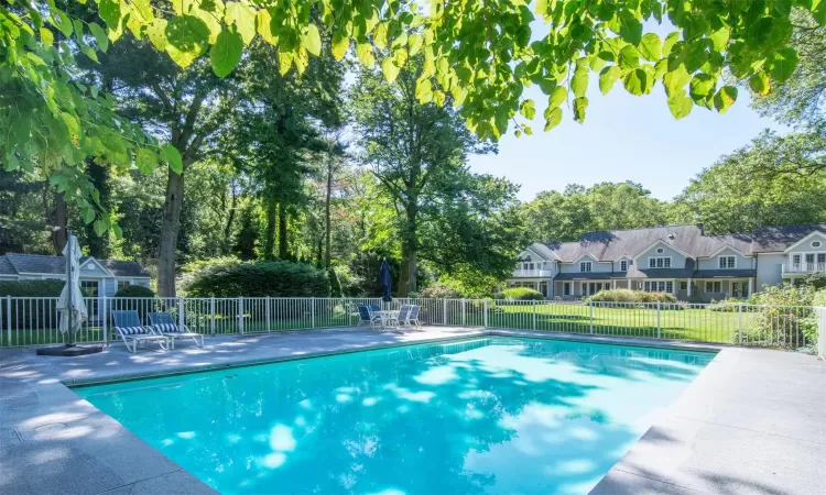 View of swimming pool with a playground and a yard