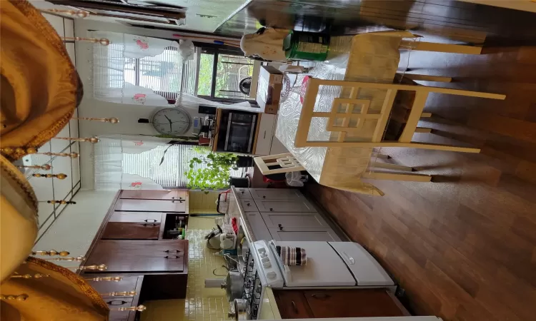 Kitchen with sink, dark wood-type flooring, range, dark brown cabinets, and tasteful backsplash