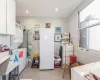 Kitchen featuring white cabinetry, stacked washer / drying machine, sink, and white fridge