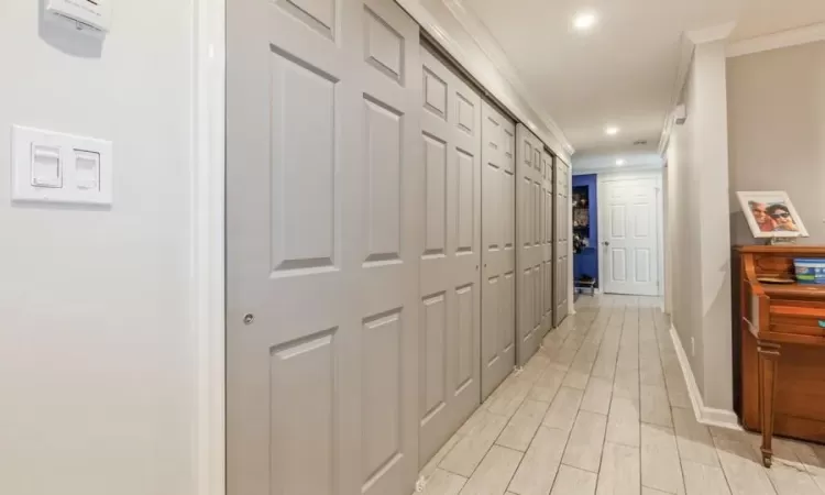 Corridor featuring ornamental molding and light hardwood / wood-style flooring