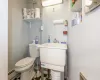 Bathroom featuring toilet, sink, and a baseboard heating unit