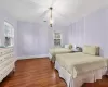 Bedroom featuring crown molding, dark hardwood / wood-style floors, and a chandelier