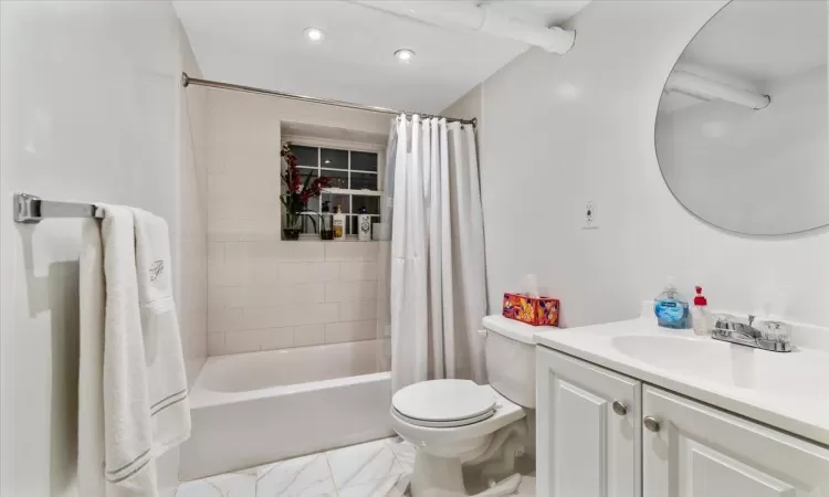 Full bathroom featuring shower / bath combination with curtain, vanity, and toilet