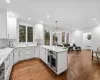 Kitchen featuring white cabinetry, radiator heating unit, sink, and hardwood / wood-style flooring